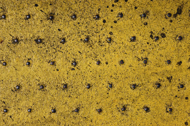 グランジスチール製の工業用ボートの床板は、黄色の防錆塗料を塗装しています。堅牢なフェリー船の金属パターン。古い点線の鉄のデッキ。摩耗した金属テクスチャ背景。モダンなデザイ� - anti rust ストックフォトと画像