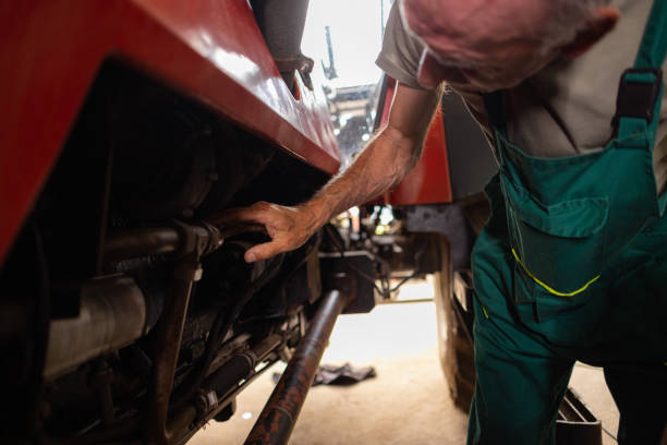 istock Mature Man Repairing Tractor in Workshop 1496596754