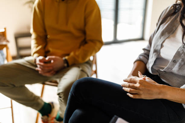 istock People sitting at group therapy session, expressing anxiety through body language 1496597502