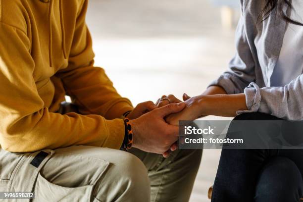 Man Holding Womans Hands During Emotional Moment At The Group Therapy Session Stock Photo - Download Image Now