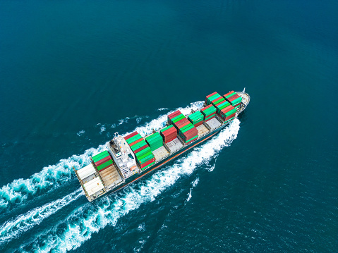Aerial view of cargo freight ship carrying containers for import export business logistic and transportation in open sea