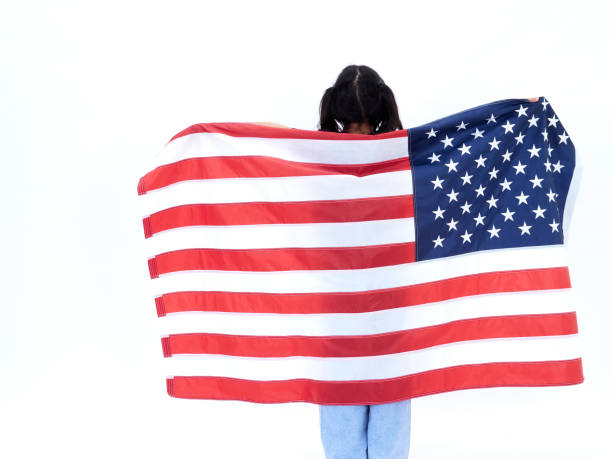 istock Little girl and American flag on white background, back view 1496598697