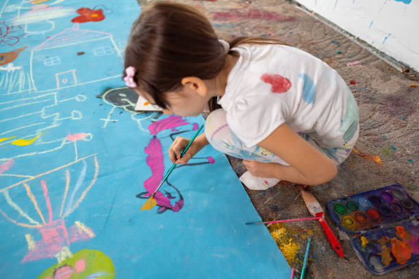 istock Elementary Schoolgirl Discovers Painting 1496602751