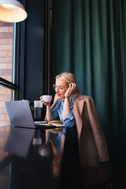 istock Smiling Business Woman Using A Laptop Computer In The Cafe 1496604453