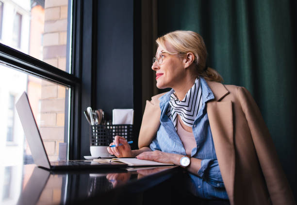 istock Smiling Business Woman Using A Laptop Computer In The Restaurant 1496604456