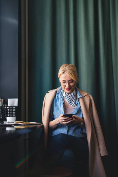 istock Happy Business Woman Using A Mobile Phone In The Cafe 1496604474