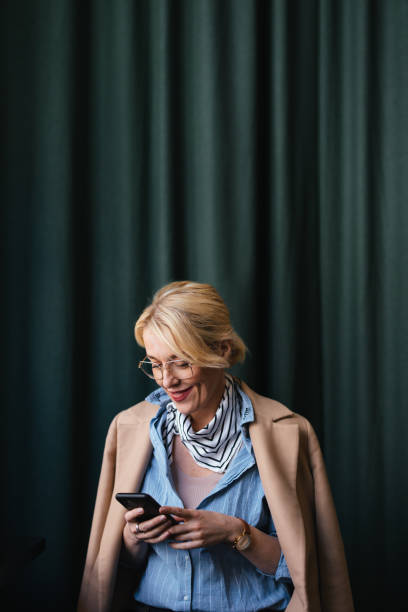 istock Smiling Business Woman Using A Mobile Phone In The Cafe 1496604570
