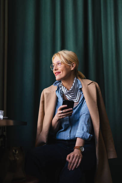 Happy Business Woman Using A Mobile Phone In The Cafe