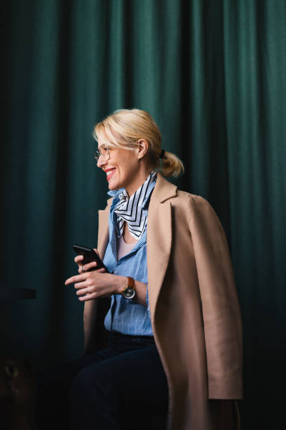 istock Smiling Business Woman Using A Mobile Phone In The Cafe 1496604584
