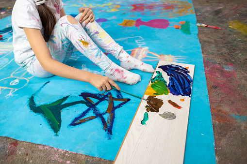 A scene filled with artistic potential as a young girl explores different colors and techniques in her elementary school art class.