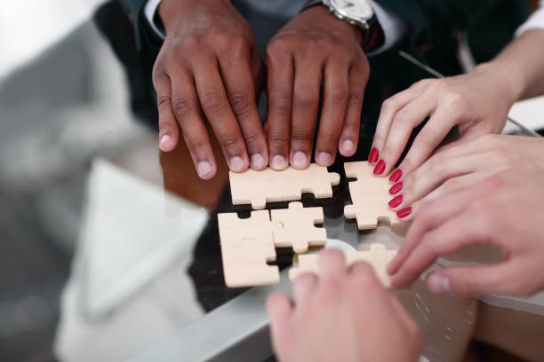 istock closeup. business team with puzzle pieces behind a Desk 1496605456