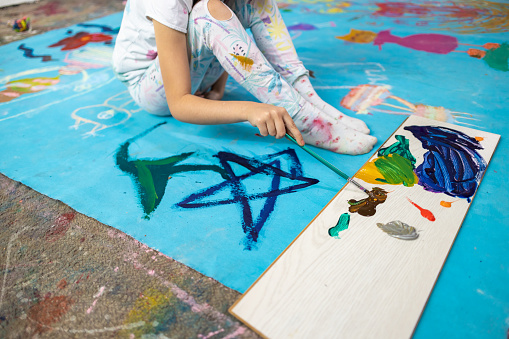 Girl artist painting on the floor
