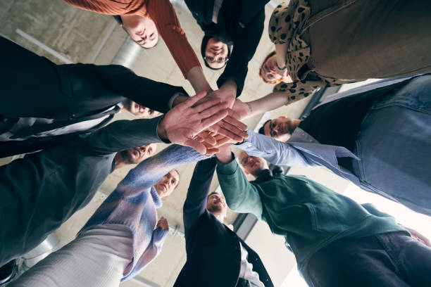 A group of businessmen holding hands together to symbolize unity and strength A group of businessmen holding hands together to symbolize unity and strength. symbolism stock pictures, royalty-free photos & images