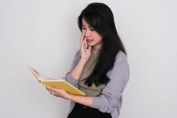 istock Asian young women showing scared expression when reading a book 1496606872