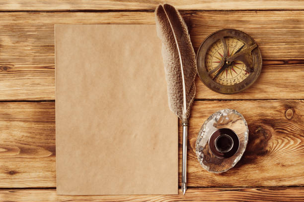 istock Old paper on brown wood background with feather 1496609744