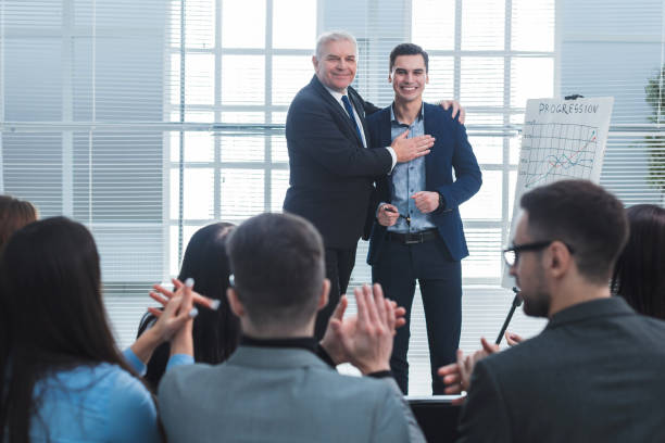 project Manager congratulating the best employee of the company stock photo