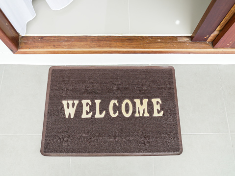 Brown welcome carpet, welcome doormat carpet placing on the floor before entering new beautiful house. Brown coir doormat with text \