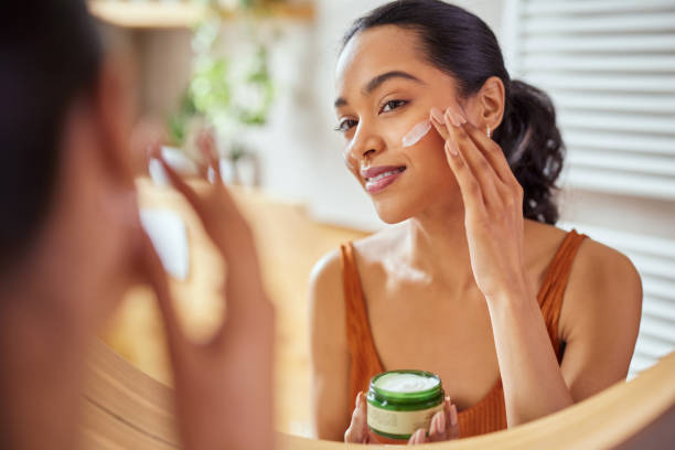 istock Woman applying face cream during morning routine 1496614968