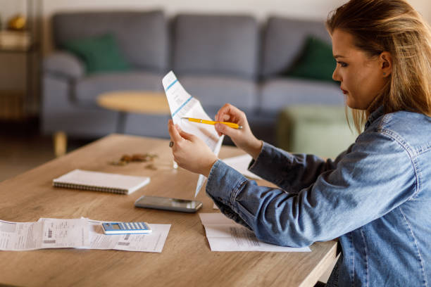 istock Young woman reading values on her financial bill when sorting out home finances 1496614977