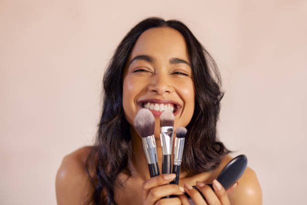 excited beauty woman holding make up brushes and compact foundation - make up cosmetics women make up brush imagens e fotografias de stock