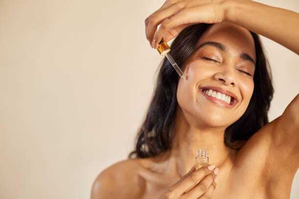 Beauty latin woman applying serum on face stock photo