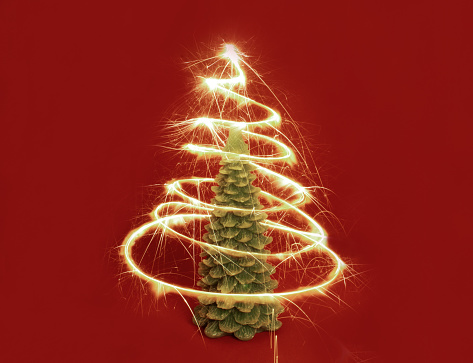 New Year's sparkle around the Christmas tree on a red background. Winter, new year concept. Front view. Card and advent minimal trendy creative concept.