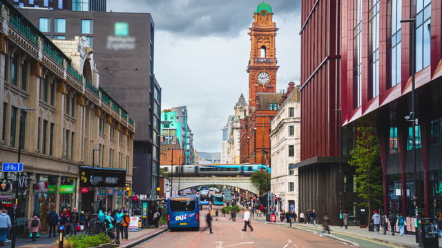 Time lapse of Crowded Commuter People and Tourist walking and traveling around Manchester Oxford Street, Kimpton Clocktower in Manchester City Centre, England, United Kingdom
