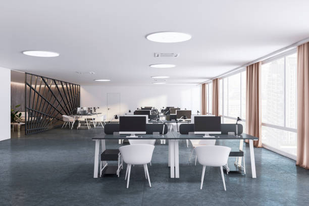 istock Front view of open space office coworking interior with comfortable workplaces, desks with computers, concrete floor, white walls, and window. Modern workspace design. 3D Rendering 1496626046