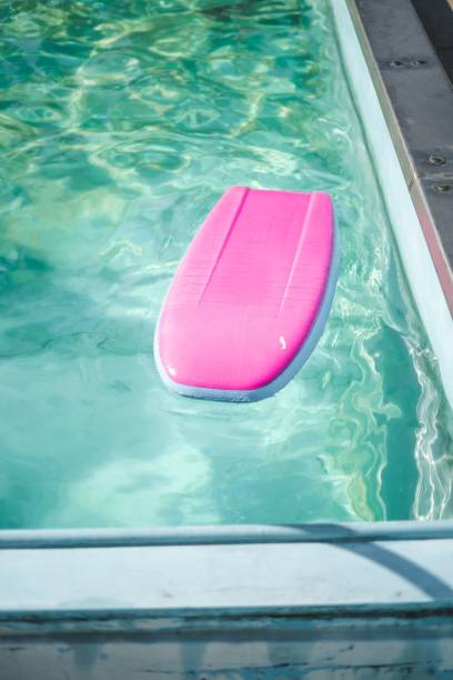 istock Pink float resting on the surface of a tranquil, blue swimming pool on a sunny day 1496627244