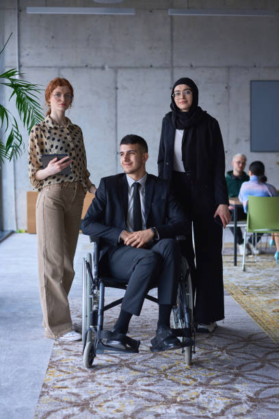 istock A businessman with disability in a wheelchair is surrounded by supportive colleagues in a modern office, showcasing the strength of teamwork, inclusivity, and empowerment in the face of challenges. 1496629087