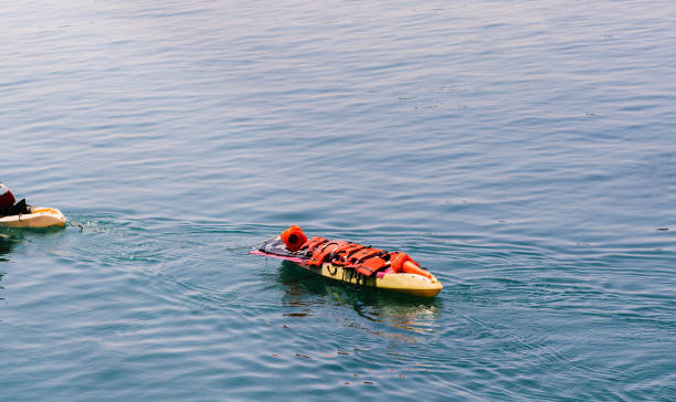 istock Person on kayak carrying life jackets on a separate boat 1496634427
