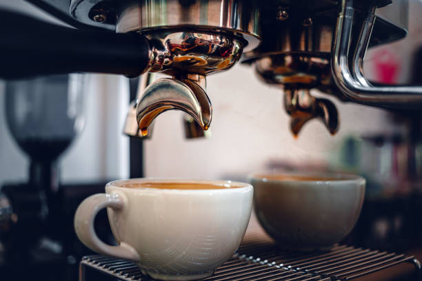 istock Espresso coffee extraction from a professional coffee machine with a bottomless filter, Close-up of a coffee drop  from the coffee machine 1496638040