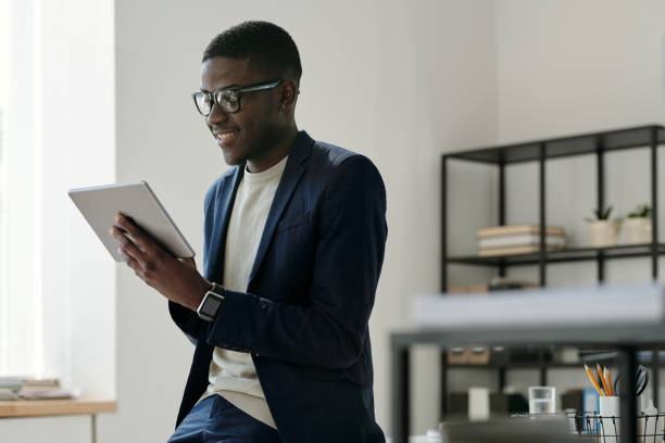 istock Happy young businessman in elegant suit looking at tablet screen 1496638846