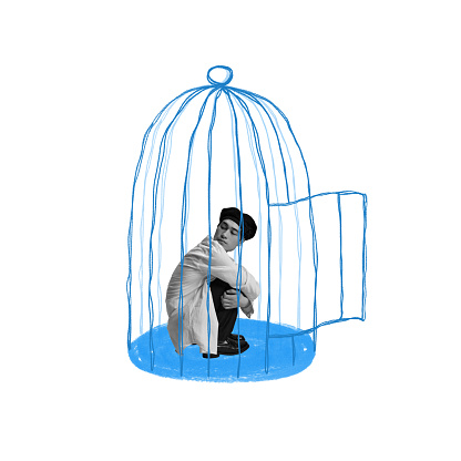 Young guy sitting into imagination bird cage. Fear of social pressure and opinion. Self-limits. Introvert life. Contemporary art collage. Concept of inner world, feelings, mental health and psychology