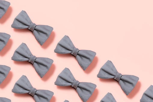 Bow tie in a row on pink background
