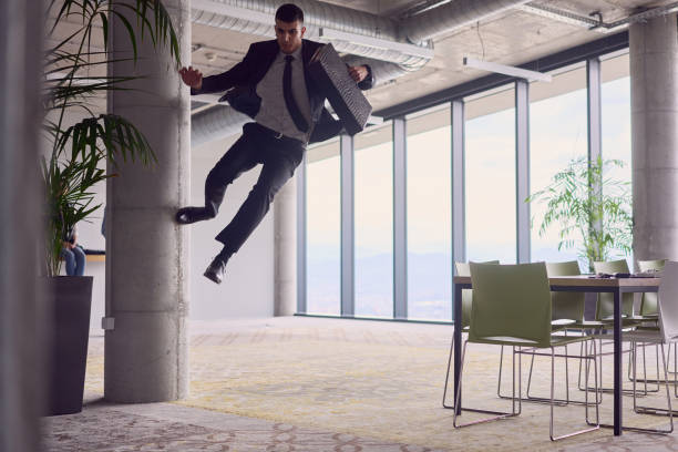 In the modern office, a businessman with a briefcase captivates everyone as he performs thrilling aerial acrobatics, defying gravity with his daring leaps and showcasing his agility with breathtaking showmanship.
