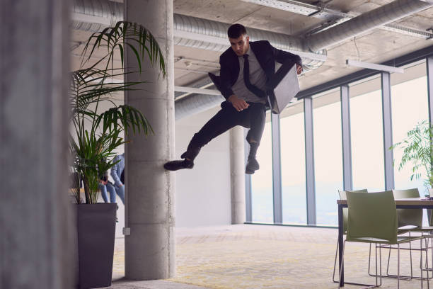 istock In the modern office, a businessman with a briefcase captivates everyone as he performs thrilling aerial acrobatics, defying gravity with his daring leaps and showcasing his agility with breathtaking showmanship. 1496644712