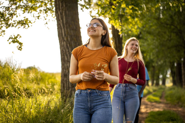 Group of young multiracial friends walking together in the woods