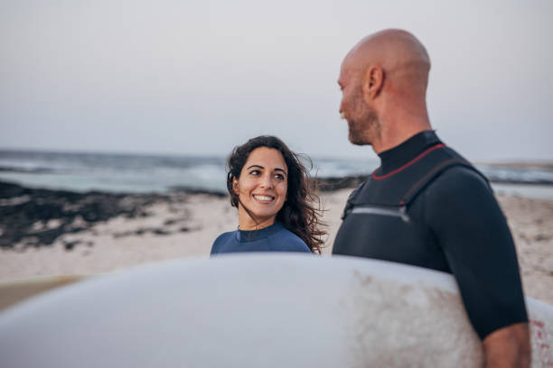 istock Couple in love going surfing on the beach 1496648902