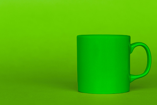 Green mug on green background.
