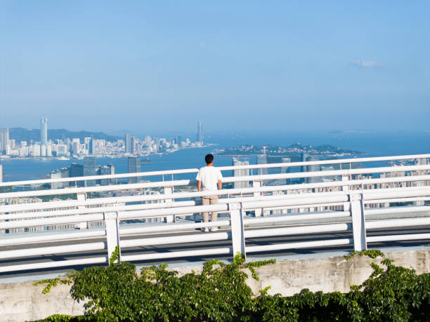 Asian man looking at the city scenery from a height