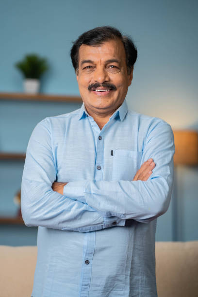 istock Vertical shot of Indian elderly senior man standing confidently by looking at camera with arms crossed - concept of proud, dignity and successful 1496655916