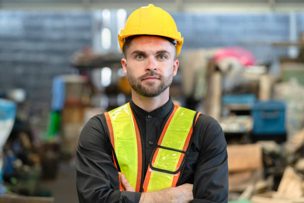 istock Young factory worker in hard hat sdaning at industry site 1496657396