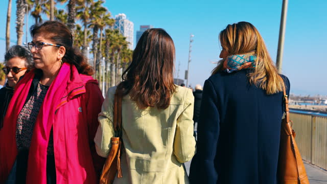 SLO MO Two women walking side by side along the Barceloneta Beach