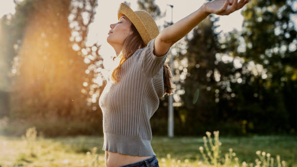 Woman with head back and arms outstretched in nature