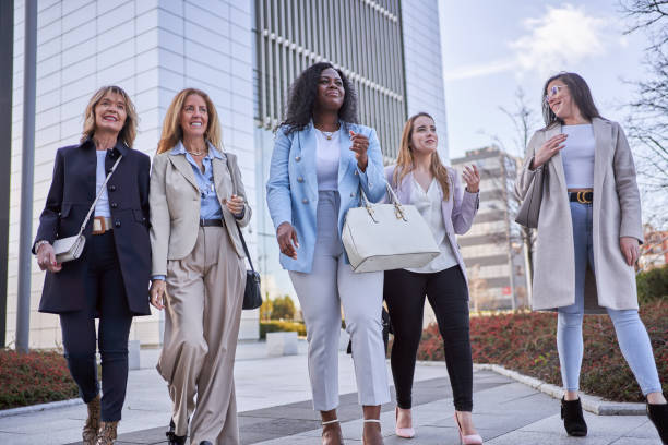istock Businesswomen talking while walking together outdoors in financial district. 1496662546