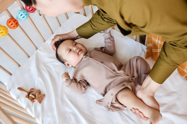 istock Mom putting her baby to sleep 1496663166