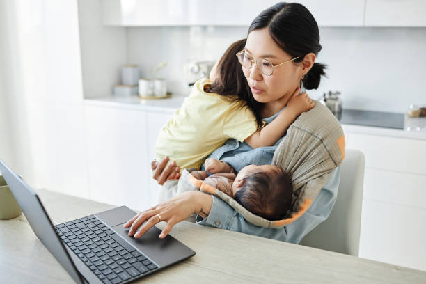 istock Woman with two kids working online on laptop 1496663295
