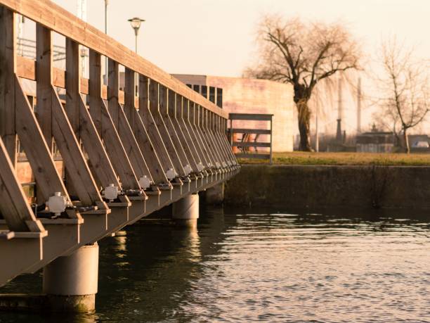 istock Railway bridge spanning over a tranquil lake with lush green trees in the background 1496663356