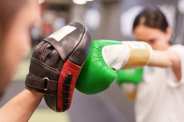 istock Female boxer punching  exercises with trainer 1496666636